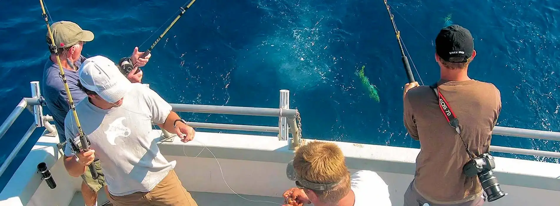 Party boat group share charter staying in Buxton standing at transom of Stormy Petrel catching some OBX mahi.