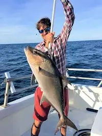 Angler holding up huge amberjack on Stormy Petrel.